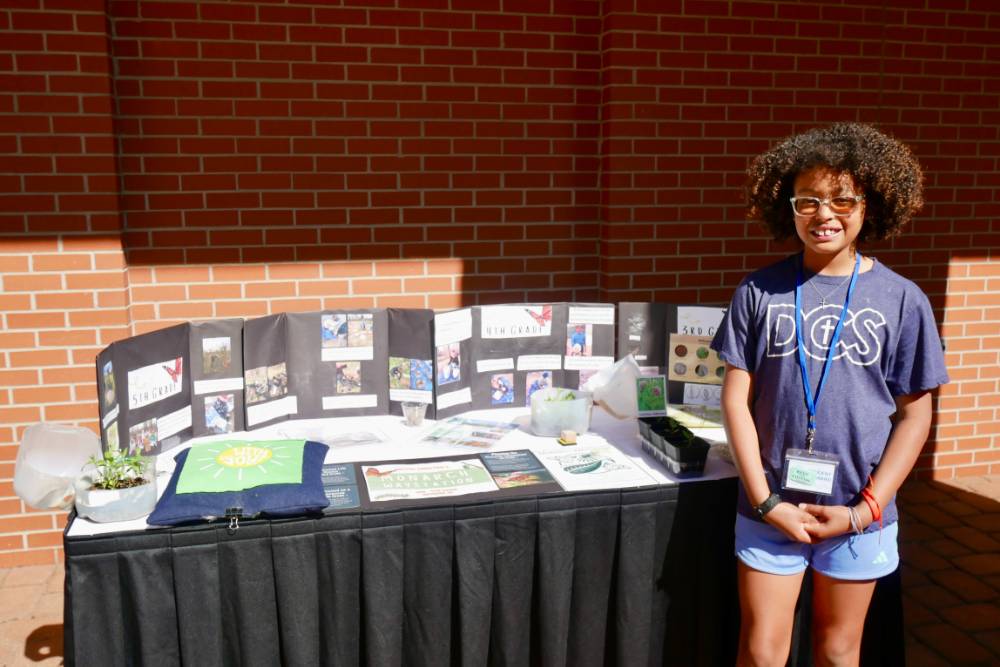 Student stands by Dutton Christian's Monarch Waystation